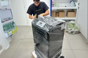 Critical drug manufacturing facility technician unwraps new equipment for sterile production.