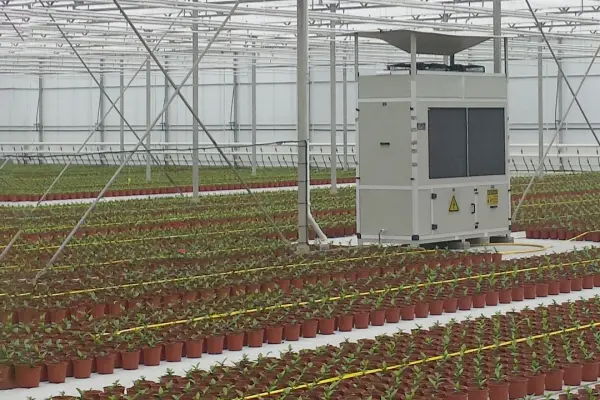 Industrial Dehumidifier controlling humidity in a large greenhouse filled with rows of potted plants