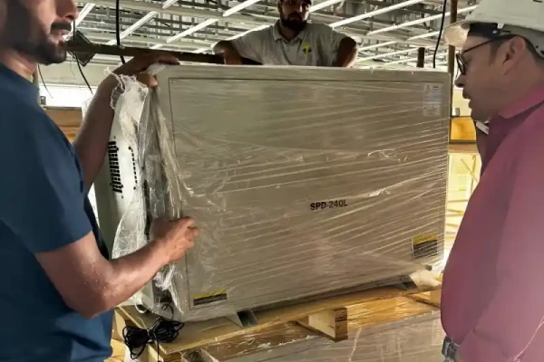 Two workers unwrap new SPD-240L units, likely for a premium hotel pool complex.