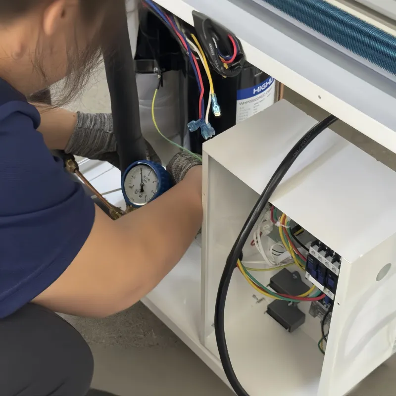 Technician performing refrigerant charging on a compressor unit.