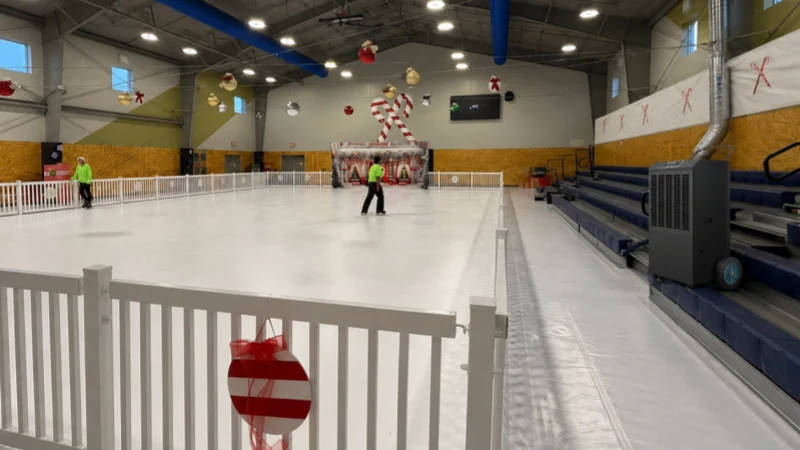 A realistic indoor ice rink scene showing light fog above the ice, ceiling condensation risk, wet entrance zones, and a industrial dehumidifier serving the rink area.