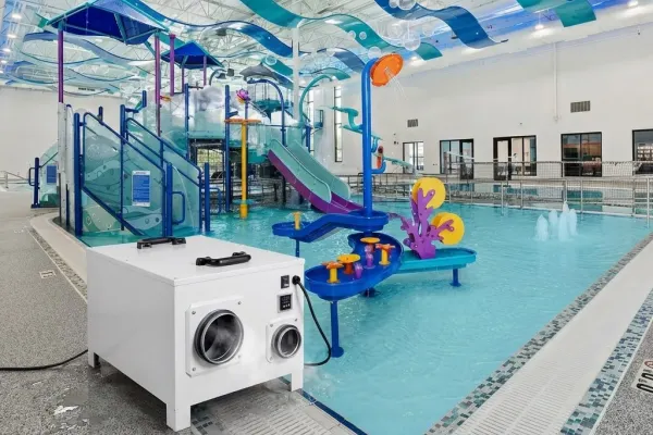 Indoor swimming pool environment with rotary desiccant dehumidifier for humidity management